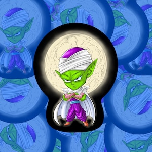 Może przedstawiać: Kreskówkowa ilustracja Piccolo z Dragon Ball Z. Postać jest zielona z fioletową głową, białym turbanem i fioletowo-białym strojem. Stoi przed pełnią księżyca na niebieskim tle.