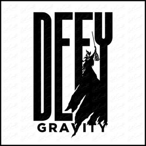 Könnte beinhalten: Schwarz-weißes Grafikdesign mit den Worten "DEFY GRAVITY" in Großbuchstaben. Eine Silhouette einer Figur, die einen Besen hält, ist in das "Y" integriert. Das Design hat einen zerrissenen, gezackten Rand.