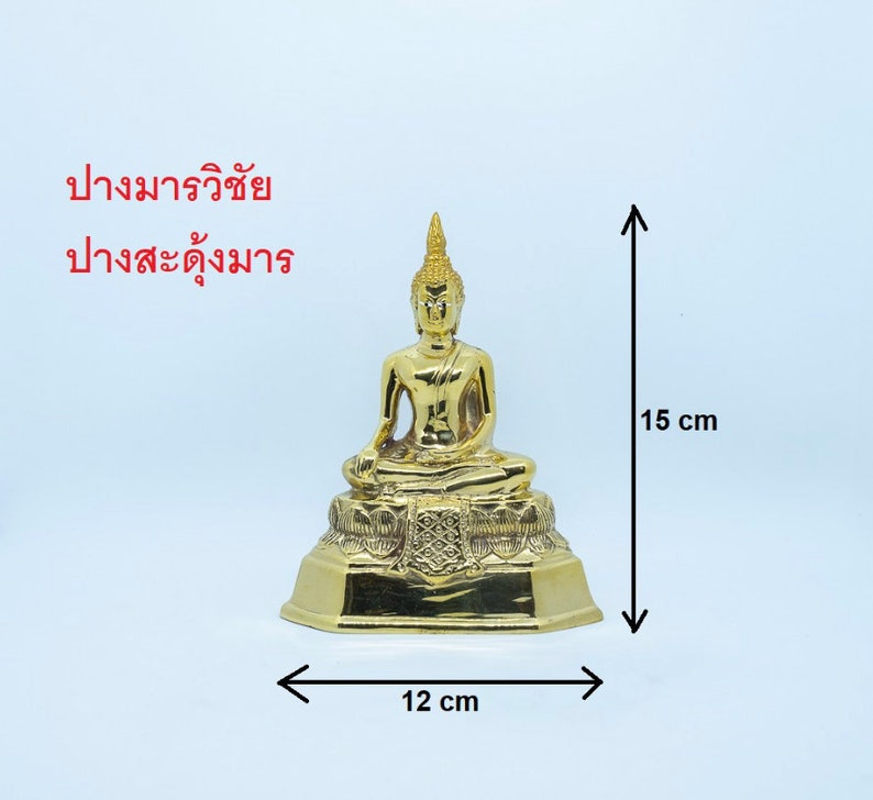 Puede incluir: Una estatua de Buda de color dorado sentada en una postura meditativa sobre una base de loto. La estatua mide 15 cm de alto y 12 cm de ancho.