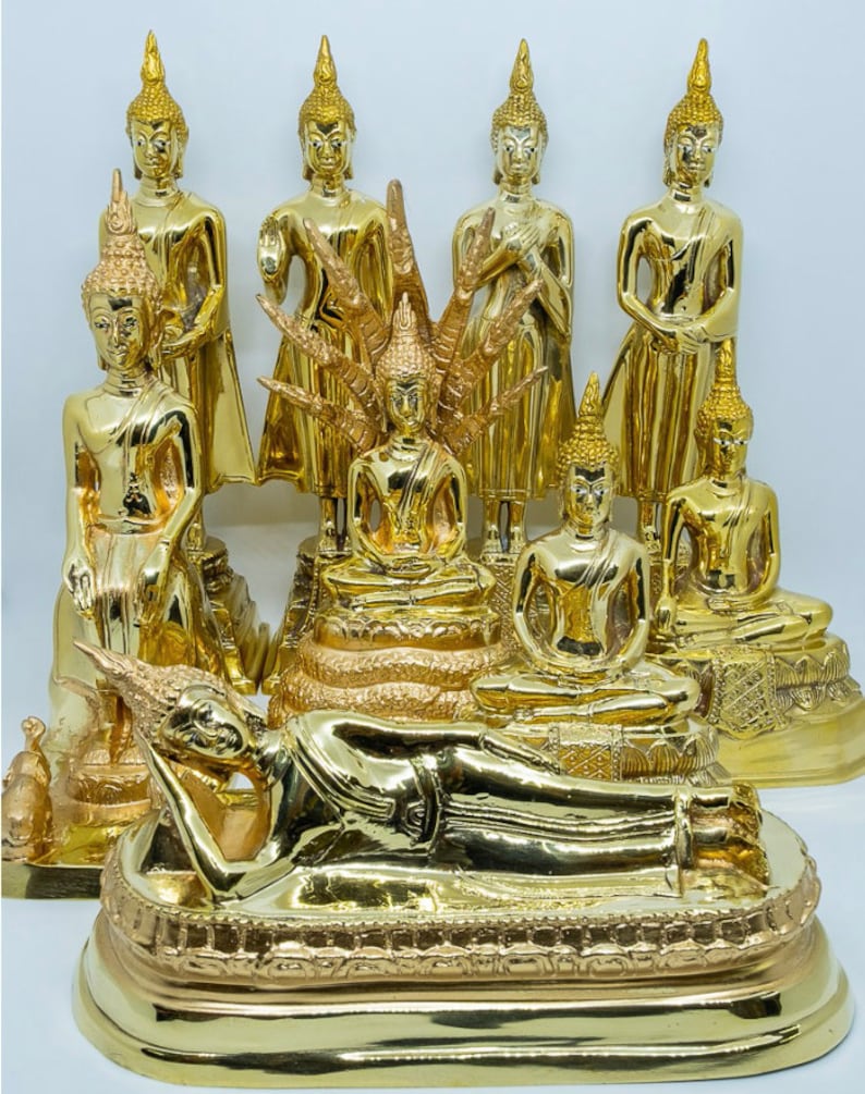 Puede incluir: Una colecci&oacute;n de nueve estatuas doradas de Buda en varias poses, incluyendo sentado, de pie y reclinado. Las estatuas est&aacute;n dispuestas en una plataforma escalonada con detalles intrincados.