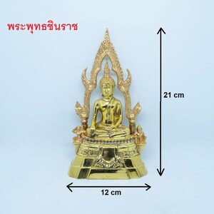 Puede incluir: Una estatua dorada de Buda sentada en posici&oacute;n de meditaci&oacute;n en un trono con una base decorativa. La estatua mide 21 cm de alto y 12 cm de ancho. El texto "พระพุทธชินราช" est&aacute; escrito en tailand&eacute;s en la parte superior de la imagen.