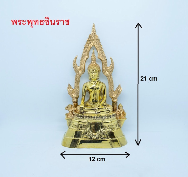 Puede incluir: Una estatua dorada de Buda sentada en posici&oacute;n de meditaci&oacute;n en un trono con una base decorativa. La estatua mide 21 cm de alto y 12 cm de ancho. El texto "พระพุทธชินราช" est&aacute; escrito en tailand&eacute;s en la parte superior de la imagen.