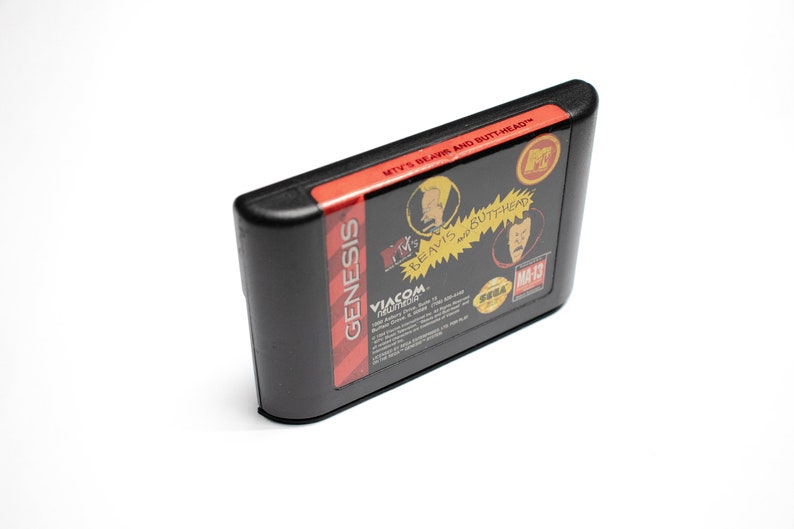 May include: A black Sega Genesis game cartridge with a red label. The label features the text "MTV's Beavis and Butt-Head" and images of the characters Beavis and Butt-Head. The game is rated "MA-13" by the ESRB.