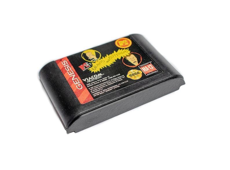 May include: A black Sega Genesis game cartridge for the video game "Beavis and Butt-Head" with a yellow, red, and black label. The label features the characters Beavis and Butt-Head, the game title, and the rating "MA-13".