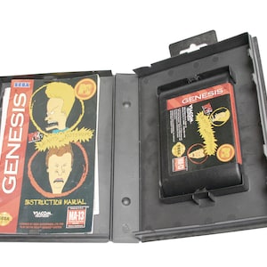 May include: A black Sega Genesis game cartridge case with a black and red game cartridge inside. The game cartridge is for the "Beavis and Butt-Head" video game. The case has a label that says "GENESIS" and "VIACOM". The instruction manual is included and has a picture of Beavis and Butt-Head on the cover.