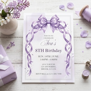 May include: A rectangular birthday invitation card featuring a large, central lavender ribbon bow with trailing ribbons forming an arch. The text reads: JOIN US TO CELEBRATE Ava's 8TH Birthday SUN. 14TH | JUNE. 1:00PM - 4:00PM AVA'S HOUSE 128 ANYWHERE, BROOK, A 01234 RSVP Mom at (123) 456-7890.