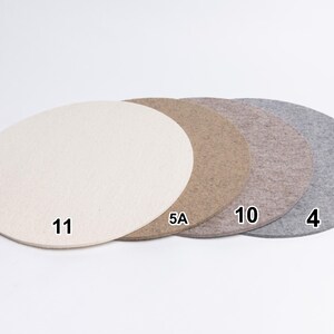 Puede incluir: Cuatro alfombrillas circulares de fieltro dispuestas en fila, con colores crema, tostado, marr&oacute;n claro y gris. Cada alfombrilla tiene un n&uacute;mero negro: 11 en la crema, 5A en la tostada, 10 en la marr&oacute;n claro y 4 en la gris.