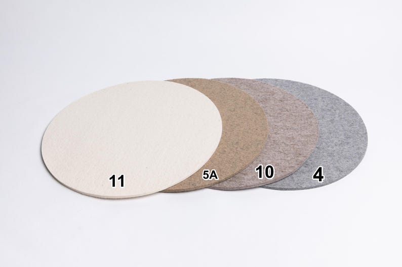 Puede incluir: Cuatro alfombrillas circulares de fieltro dispuestas en fila, con colores crema, tostado, marr&oacute;n claro y gris. Cada alfombrilla tiene un n&uacute;mero negro: 11 en la crema, 5A en la tostada, 10 en la marr&oacute;n claro y 4 en la gris.