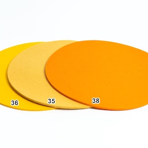 Puede incluir: Tres discos circulares y planos en tonos amarillo, naranja claro y naranja brillante. Cada disco presenta una peque&ntilde;a etiqueta num&eacute;rica blanca impresa en su superficie: el disco amarillo est&aacute; marcado con 36, el naranja claro con 35 y el naranja con 38.