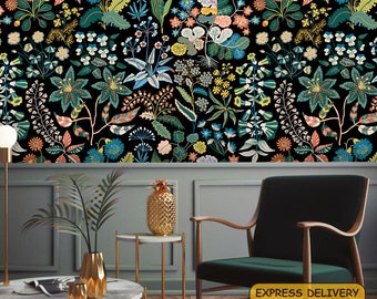 May include: A black and white floral wallpaper featuring a variety of flowers and leaves. The wallpaper is in a living room setting with a green chair, a gold pineapple, and a gold vase with green plants.