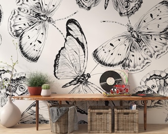 May include: A black and white butterfly wallpaper design. Large, detailed illustrations of butterflies cover the white background. A wooden table holds plants, baskets, and a record player. The room has a natural, artistic theme.