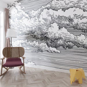 May include: A black and white illustration of clouds on a white background. The illustration is printed on a wall and is part of a home decor design. A rocking chair and a small stool are in the foreground.