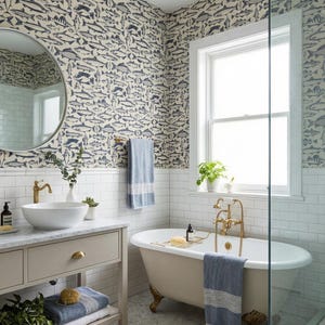 May include: A bathroom with a vintage clawfoot tub, a vanity with a round sink, and a shower. The walls are decorated with a fish pattern wallpaper. The room has a window and a round mirror.
