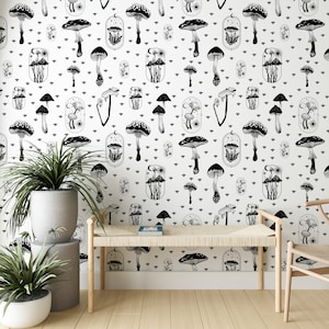 May include: Black and white wallpaper with a repeating pattern of mushrooms and celestial elements. The wallpaper features a variety of mushroom shapes and sizes, as well as stars, moons, and suns. The wallpaper is set against a white background.