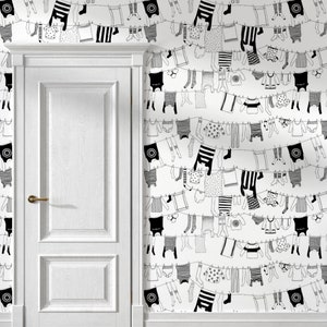 May include: White wallpaper featuring a repeating pattern of black and white clothing hanging on clotheslines. The clothing includes shirts, underwear, socks, and dresses. A white door with a gold handle is on the left side of the image.