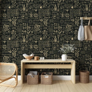 May include: Black and gold wallpaper with a repeating pattern of botanical illustrations, including plants, flowers, and vials. The wallpaper is displayed in a room with a wooden table, a wicker chair, and a potted plant.