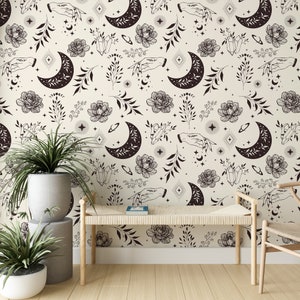 May include: A beige wallpaper with a repeating pattern of black crescent moons, stars, flowers, crystals, and hands. The wallpaper is in a room with a wooden bench and a chair.
