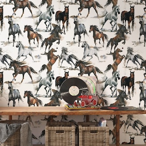 Puede incluir: Una pared blanca con un patrón repetitivo de caballos de acuarela en varias poses y colores. Una mesa de madera con dos cestas de mimbre y un camión de juguete rojo se encuentra frente a la pared.