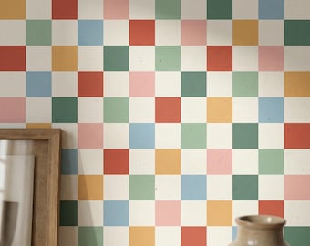 Peut inclure: Papier peint à motif de carreaux multicolores. Les carrés sont dans des tons de rouge, rose, vert, bleu et jaune, sur un fond crème. Un cadre en bois et un vase marron sont au premier plan.