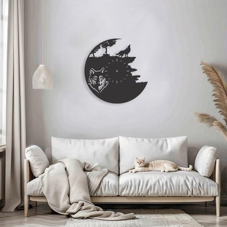 May include: Black and white wall clock with a wolf design. The clock is mounted on a white wall above a white couch. A cat is sitting on the couch.