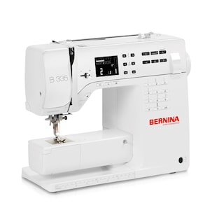 Peut inclure: Une machine à coudre Bernina B 335 blanche avec un écran numérique et un logo Bernina rouge.