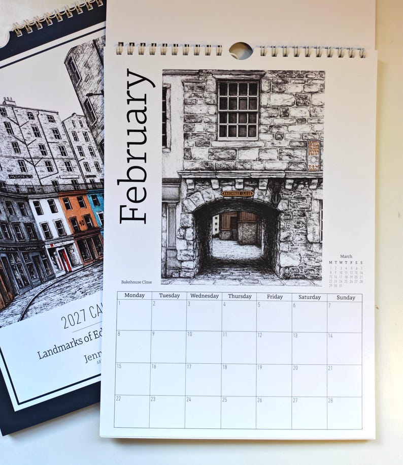 May include: A 2027 wall calendar featuring a black and white ink illustration of Bakehouse Close in Edinburgh for the month of February. The page displays a grid for the month, a small March calendar, and a detailed stone archway drawing.