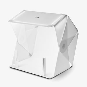 Op de afbeelding: Witte opvouwbare fotostudio-lichtbox met een witte achtergrond en twee witte scheidingswanden. De box is gemaakt van lichtgewicht materiaal en is gemakkelijk te monteren.