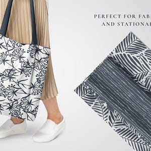 May include: A white tote bag with a black floral pattern. The bag has two black handles. The text "PERFECT FOR FABRICS AND STATIONARY" is visible in the background.