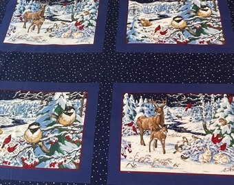 May include: A navy blue and white winter-themed quilt featuring four square panels with snowy landscape scenes. Each panel depicts deer, birds, and rabbits in a winter forest. The quilt has a white polka dot pattern and a decorative border.