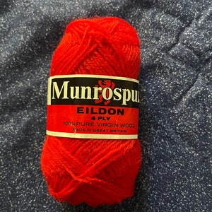 May include: A ball of red yarn labeled "Munrospun Eildon 4 Ply 100% Pure Virgin Wool Made in Great Britain".