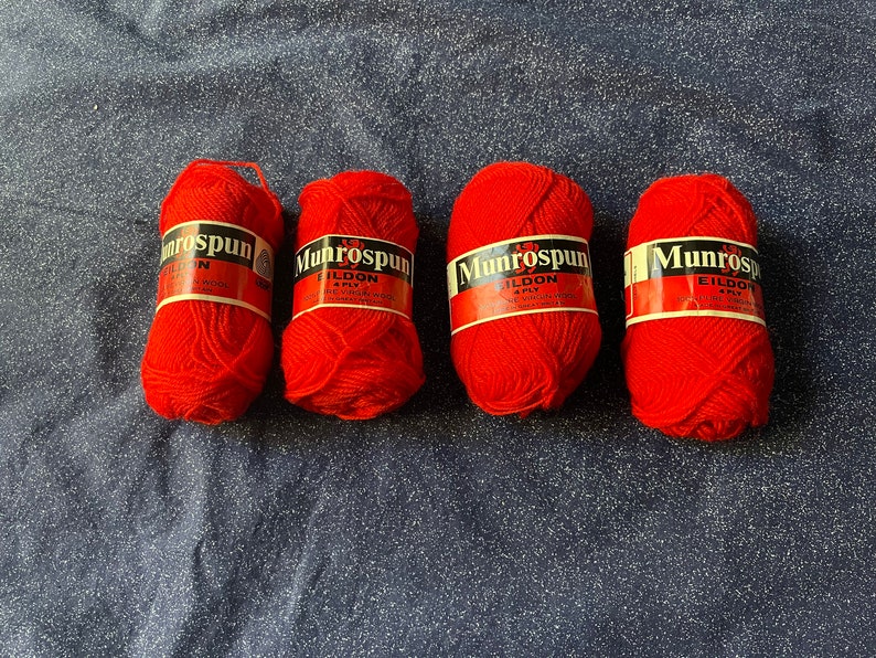 May include: Four balls of red yarn labeled "Munrospun Eildon 4 Ply 100% Pure Virgin Wool Made in Great Britain"