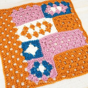 May include: A crocheted square with a patchwork design featuring orange, pink, blue and white squares. The square is made with a granny stitch pattern.