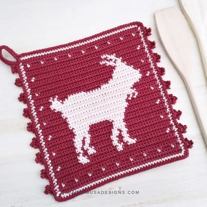 K&ouml;nnte beinhalten: Roter H&auml;kel-Topflappen mit einem wei&szlig;en Ziegenmotiv und einem wei&szlig;en H&auml;kelrand. Der Topflappen hat eine Schlaufe zum Aufh&auml;ngen.