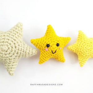 May include: Three crocheted stars, one yellow with a smiling face, one cream, and one smaller yellow. The stars are on a white background.