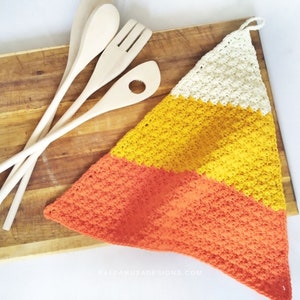May include: A triangular crocheted pot holder in orange, yellow, and white. The pot holder has a loop at the top for hanging.