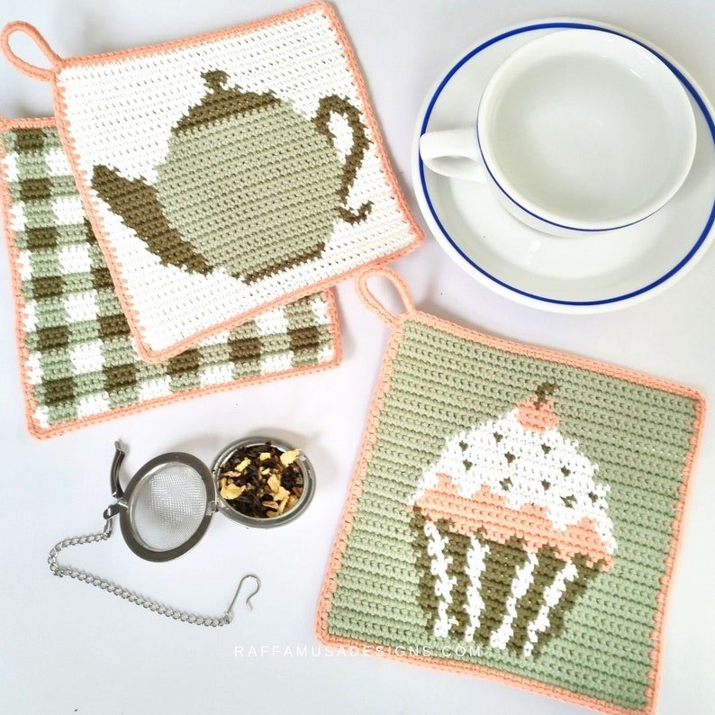 May include: Three crocheted pot holders with a pink border. One pot holder features a green teapot, another has a green and white gingham pattern, and the third has a green cupcake with pink frosting and white sprinkles.