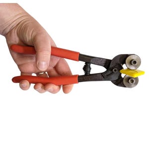 Può includere: Una pinza per piastrelle con manici rossi e un telaio in metallo nero. L'utensile è dotato di una molla e di una guida di taglio gialla. Progettata per tagliare piastrelle e altri materiali.