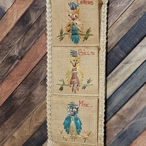 May include: A woven wall organizer with three pockets, each featuring a colorful owl design. The pockets are labeled "Letters", "Bills", and "Misc."