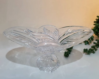 May include: A clear glass bowl with a pedestal base. The bowl has a decorative design of wheat stalks and leaves.