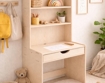 May include: A light-colored wooden desk with a hutch, featuring shelves with toys and decor. A drawer is below the desk surface. A rainbow rug and a teddy bear are on the floor. A yellow backpack hangs on the wall.