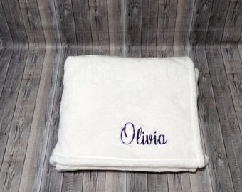 May include: White plush blanket with the name Olivia embroidered in purple.