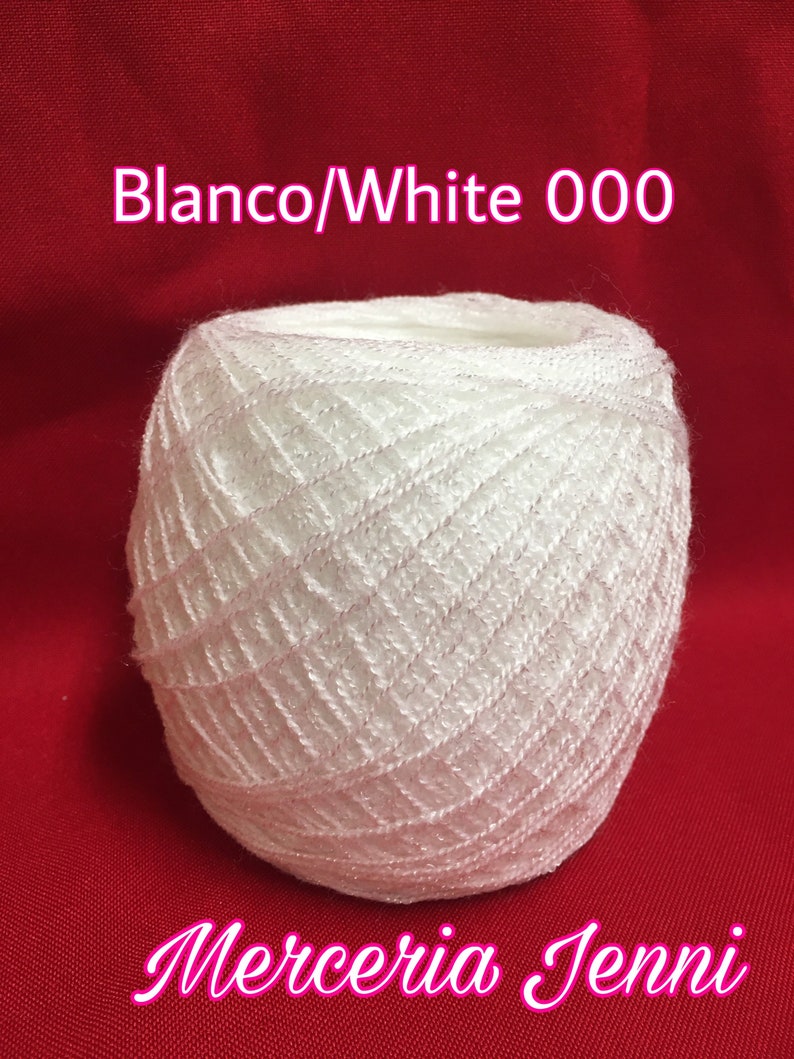 Puede incluir: Una bola de hilo blanco con un patr&oacute;n de diamantes. El hilo est&aacute; etiquetado como "Blanco/White 000" y "Merceria Jenni".