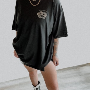 K&ouml;nnte beinhalten: Schwarzes Oversize-T-Shirt mit einem Motiv eines Motorrads und dem Text "Hell Raiser Moto Baddies".
