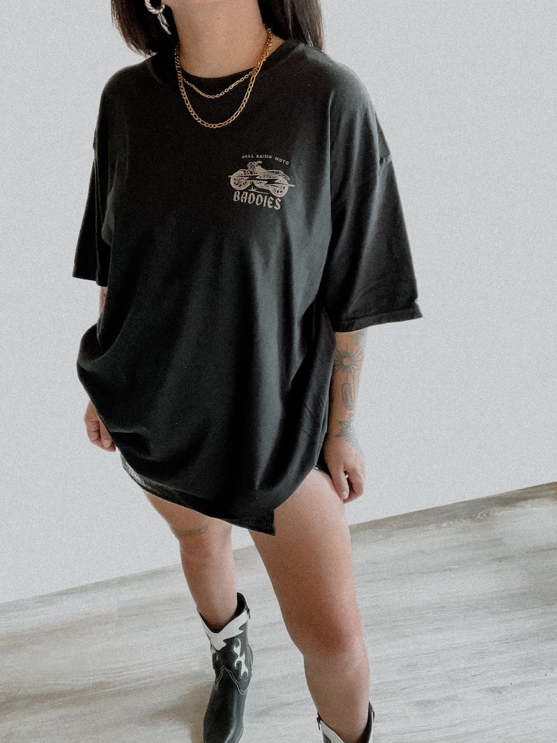 K&ouml;nnte beinhalten: Schwarzes Oversize-T-Shirt mit einem Motiv eines Motorrads und dem Text "Hell Raiser Moto Baddies".