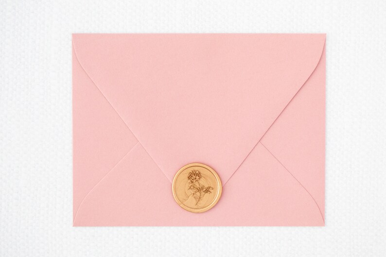 May include: A pink envelope with a gold wax seal featuring a floral design.