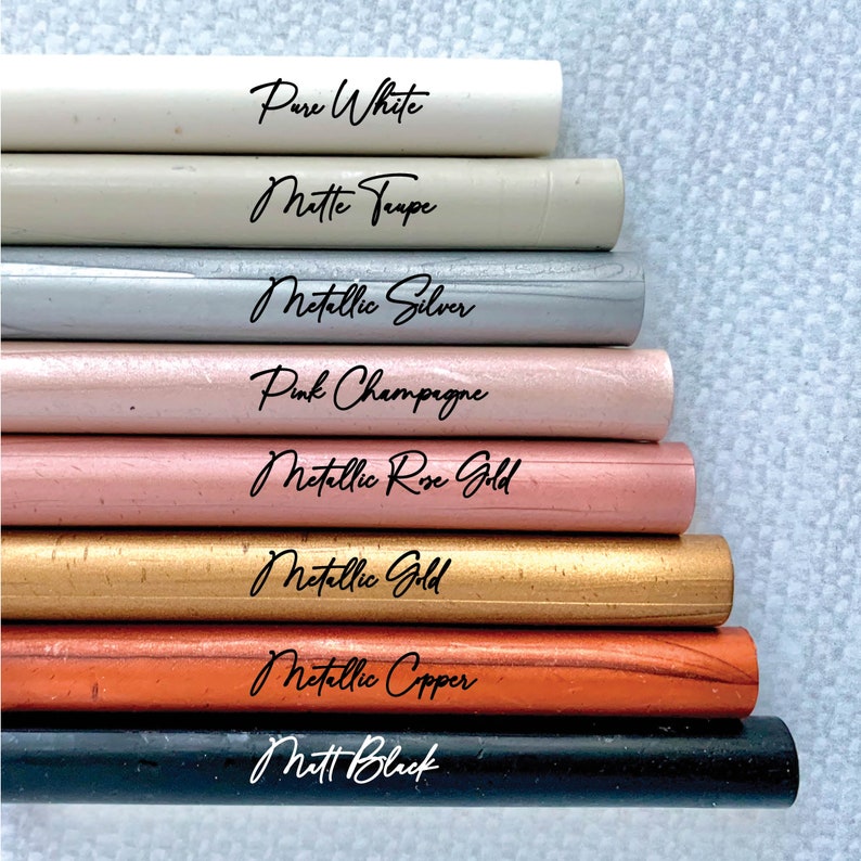 May include: A stack of eight different colored wax sticks, from top to bottom: Pure White, Matte Taupe, Metallic Silver, Pink Champagne, Metallic Rose Gold, Metallic Gold, Metallic Copper, and Matt Black.