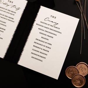 K&ouml;nnte beinhalten: Elegantes Hochzeitszeremonie-Programm mit schwarzem Text auf cremefarbenem Papier. Das Programm listet die Reihenfolge der Ereignisse auf, einschlie&szlig;lich der Sitzordnung der Familie, Lesungen und dem Austausch der Gel&uuml;bde. Das Programm ist mit einem schwarzen Band gebunden und mit dekorativen Wachssiegeln versehen.