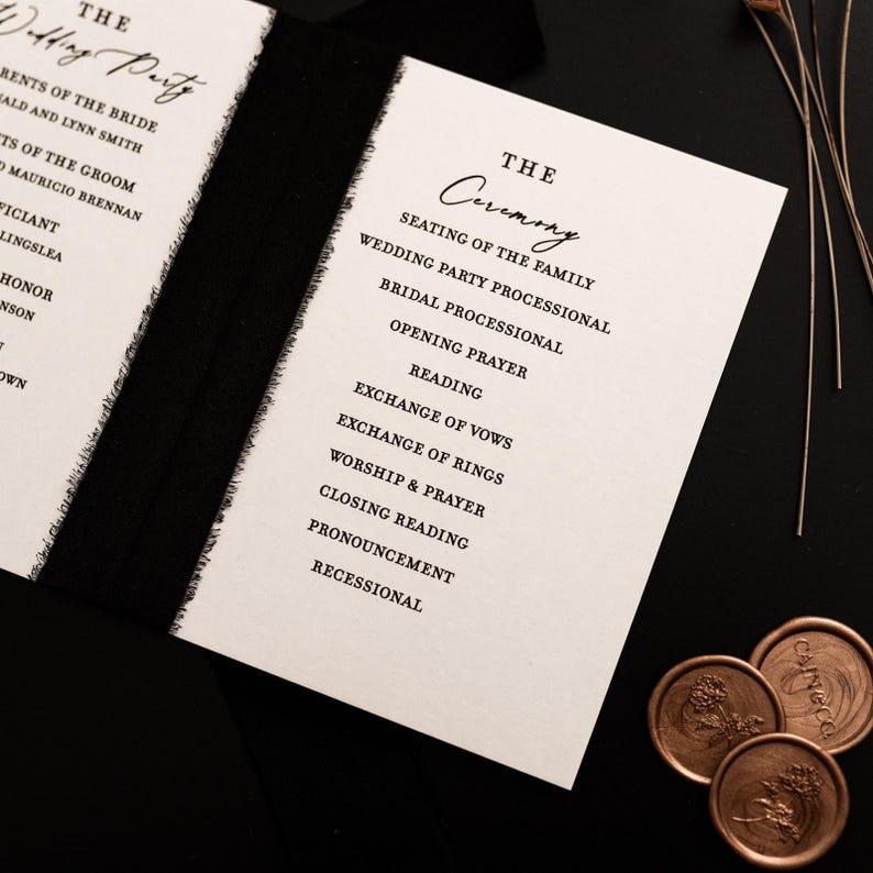 K&ouml;nnte beinhalten: Elegantes Hochzeitszeremonie-Programm mit schwarzem Text auf cremefarbenem Papier. Das Programm listet die Reihenfolge der Ereignisse auf, einschlie&szlig;lich der Sitzordnung der Familie, Lesungen und dem Austausch der Gel&uuml;bde. Das Programm ist mit einem schwarzen Band gebunden und mit dekorativen Wachssiegeln versehen.