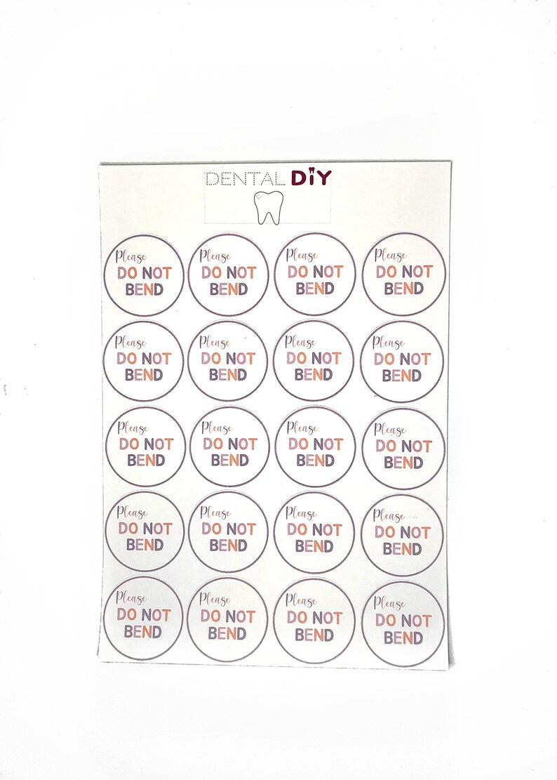 May include: A sheet of circular stickers, each bearing the text "Please Do Not Bend" in a brown font. The stickers are arranged in a grid pattern on a white background. The words "DENTAL DIY" and a tooth graphic are at the top.