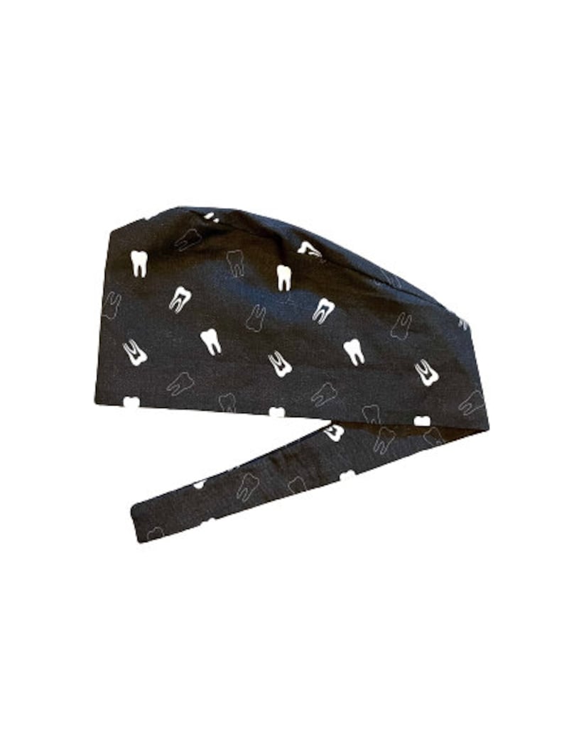 May include: A black scrub cap with a white tooth pattern. The cap has a tie on the back.